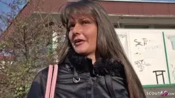 Junge Frau mit schwarzer Lederjacke vor zerfallenem Gebäude