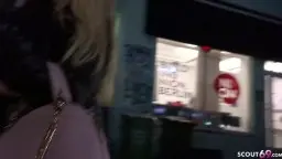 Blondine mit blonder Mähne im schwarzen Mantel vor dem Logo von scout69