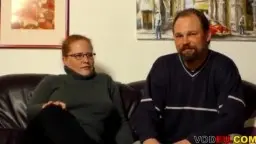 Molliges Paar mit Brille Sitzt auf Ledercouch