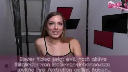 Brünette in Netz-Bodystocking liegt mit gespreizten Beinen auf schwarzer Liege