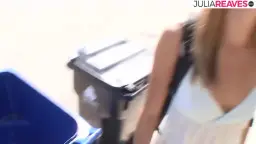 Blonde Frau draußen vor Haus lächelt in Kamera