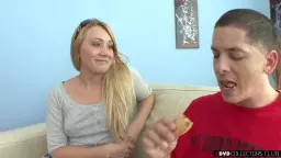 Blondine in Shorts küsst Mann auf Sofa