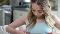 Zwei blonde Teens küssen sich auf hellem Sofa