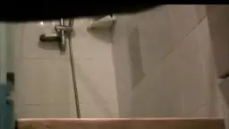 Reife Frau von hinten in heller Duschkabine, Po nah.
