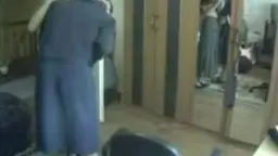 Mann im Bademantel steht vor Frau auf Knien im Schlafzimmer