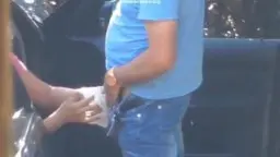 Voyeurblick durch Holzpfosten auf Paar am Auto
