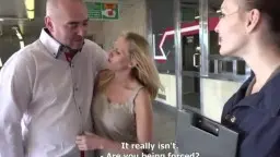 Blonde Frau und Mann an Bushaltestelle mit Kameraassistentin