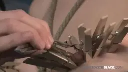Sasha Grey gefesselt in Lederkorsett an Metallrahmen
