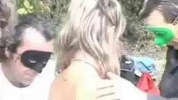 Blonde Frau kniet vor nacktem Mann, lutscht Schwanz im Freien