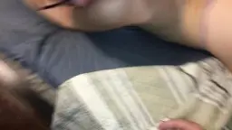 Frau mit Brille gefesselt auf Bett, Po im Vordergrund.