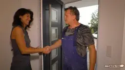 Frau in grauem Top küsst Mann in Küche