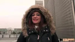 Sie in dunkler Parka-Jacke mit Pelz-Kapuze, roter Lippenstift, draußen auf Dach