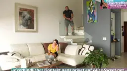 Brille-Mädchen kniet vor Couch, Gesicht nah am Schwanz